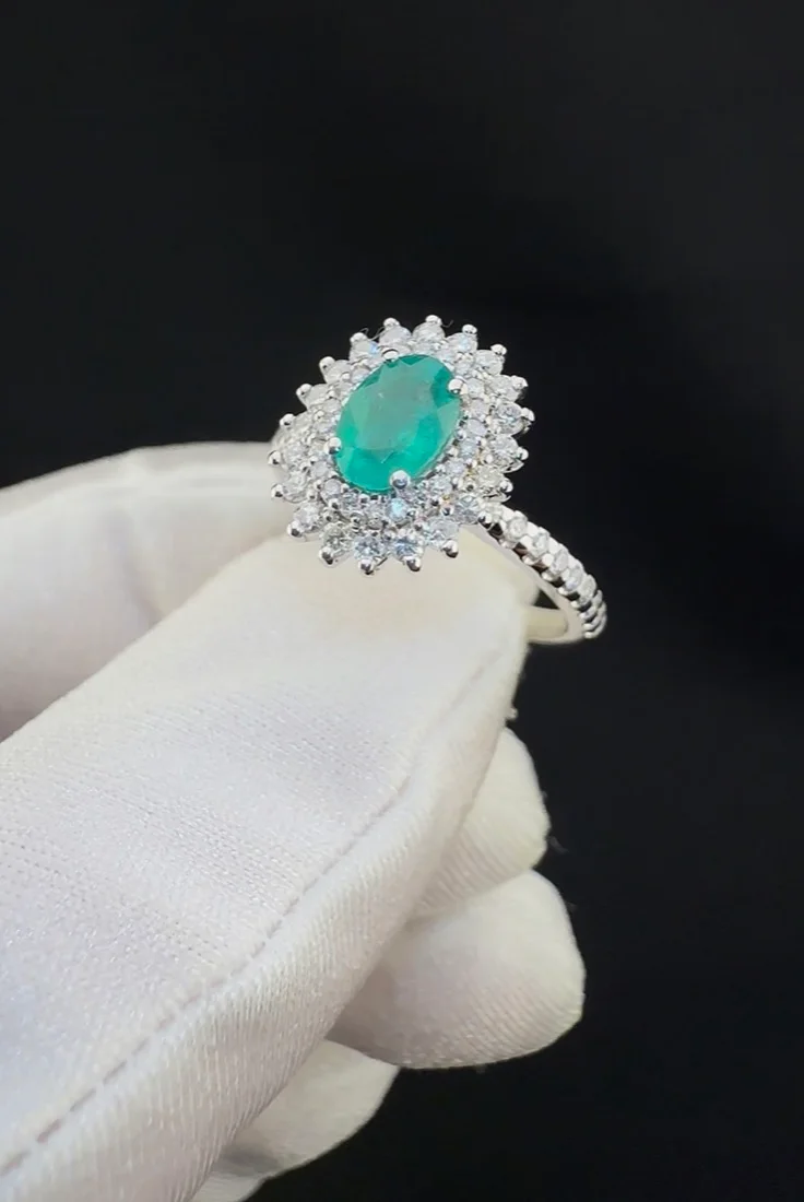 Anel com pedra verde oval e halo de diamantes