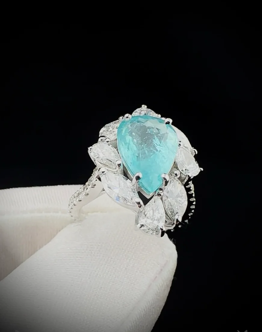 Anel com pedra azul em gota cercada de diamantes
